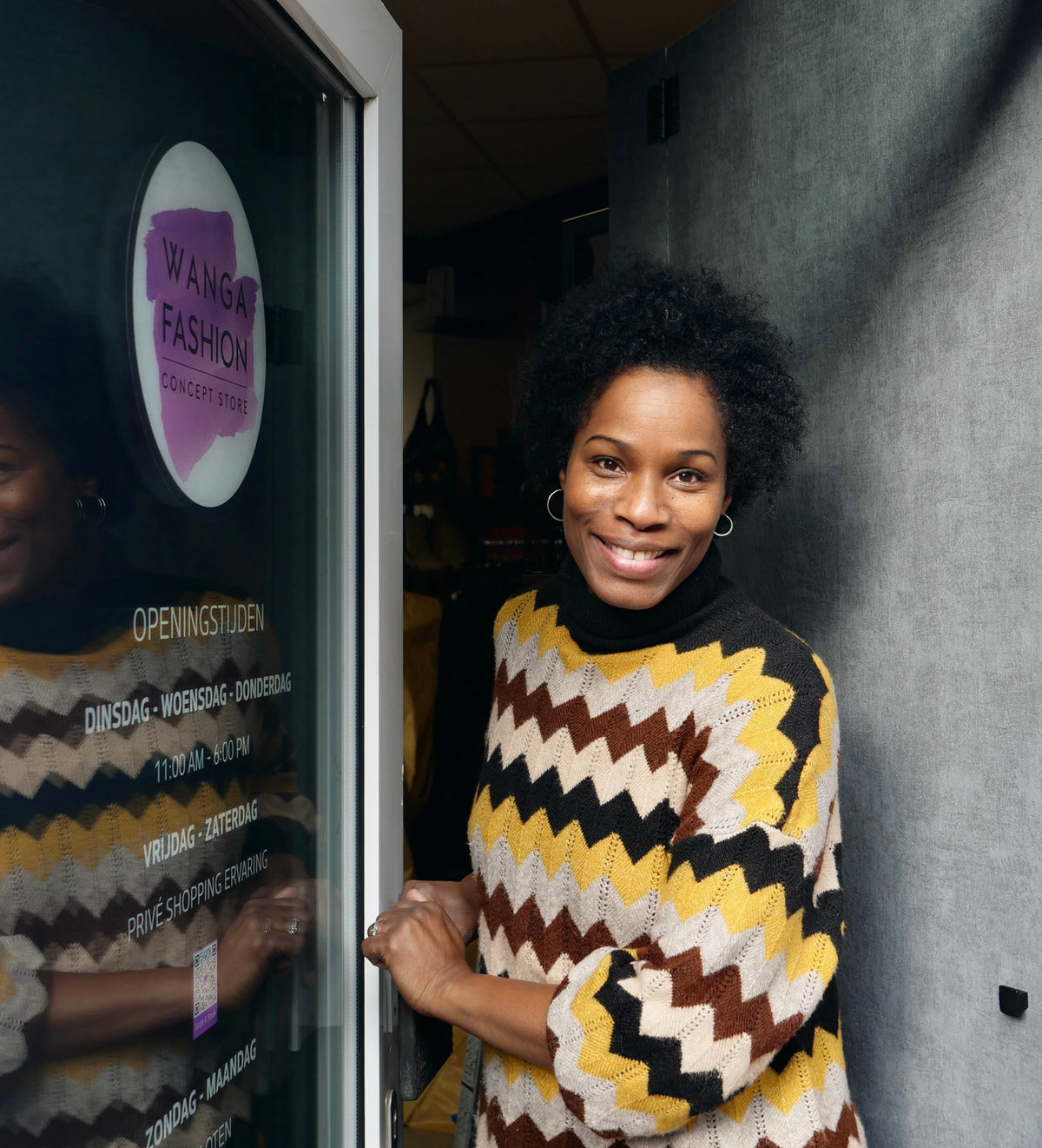 Dulce smiling in the doorway of Wanga Fashion